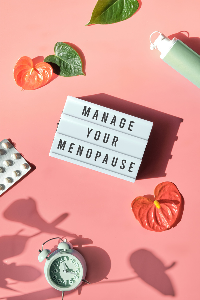 Text Manage Your Menopause. Pink Frame in Hand. Menopause, Hormone  Concept. Pink Background with Exotic Leaves, Flowers, Pills, Estrogene Gel.
